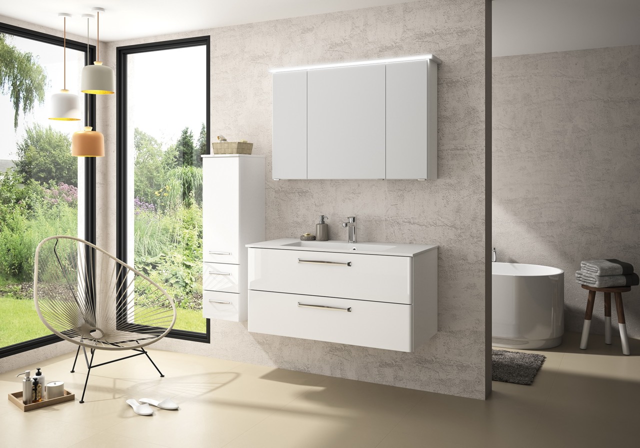 Moderner Badezimmerblock in Weiß mit Hängeschrank, Waschbecken und Schubladen, seitliche Perspektive, mit Blick auf einen Garten durch große Fenster.