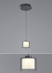 Moderne LED-Pendelleuchte KLARA in zylindrischer Form, von unten betrachtet, mit einem eleganten, transparenten Schirm und warmem Licht.