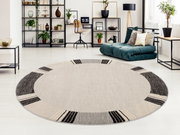 Runder Frisé-Teppich in einem modernen Wohnzimmer mit hellem Holzboden, umgeben von stilvollen Regalen und einem grünen Sofa. Perspektive von oben.