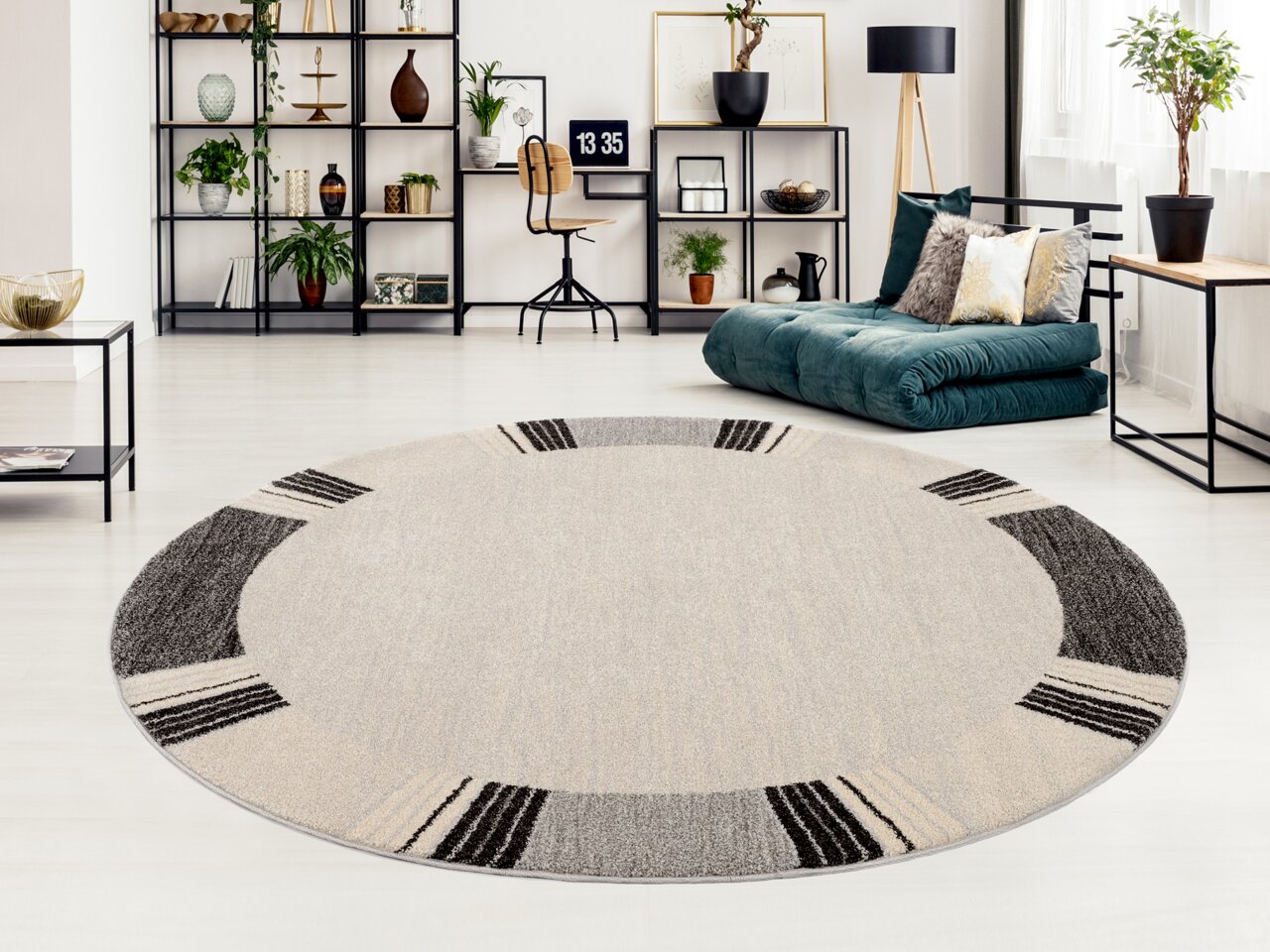 Runder Frisé-Teppich in einem modernen Wohnzimmer mit hellem Holzboden, umgeben von stilvollen Regalen und einem grünen Sofa. Perspektive von oben.