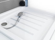 Blick auf eine Duschwanne mit Anti-Rutschband und Handbrause.