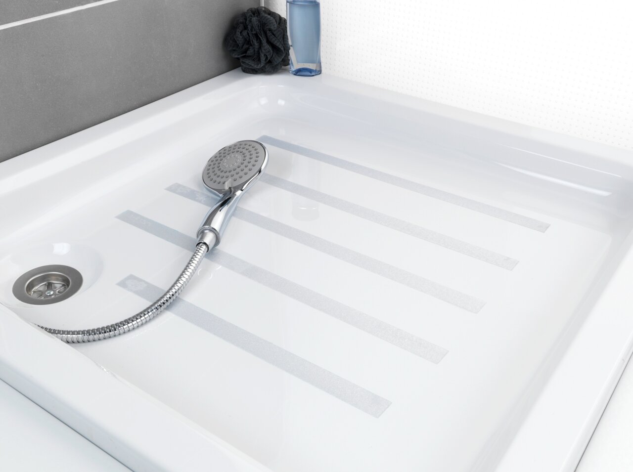 Blick auf eine Duschwanne mit Anti-Rutschband und Handbrause.