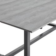 Nahaufnahme eines grauen Tischs mit Metallgestell, perspektivisch von der Seite aufgenommen.