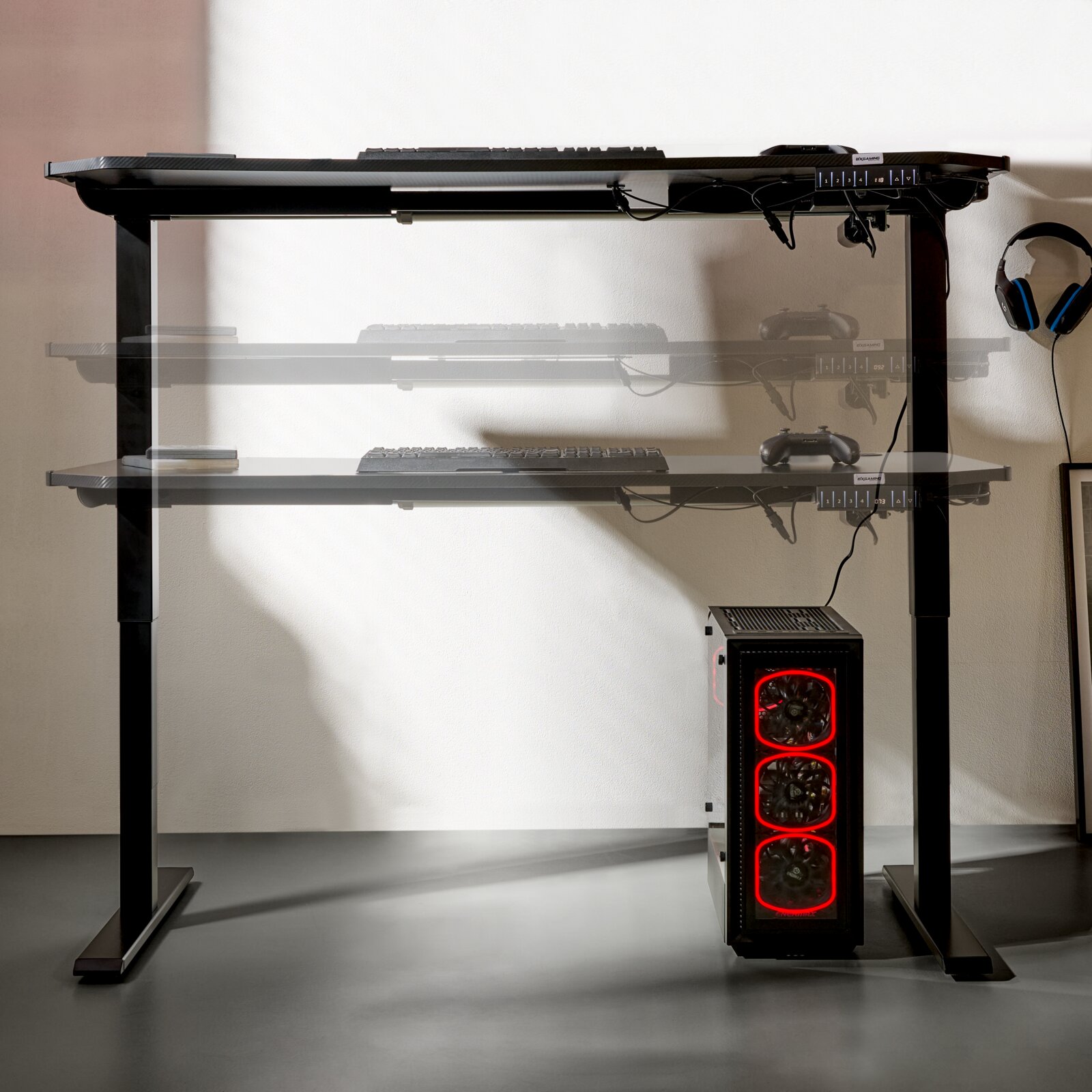 Schwarzer höhenverstellbarer Gaming-Schreibtisch mit Tastatur, Kabelmanagement und PC-Tower mit roten LED-Lüftern darunter, Seitenansicht von vorne (Profilperspektive)