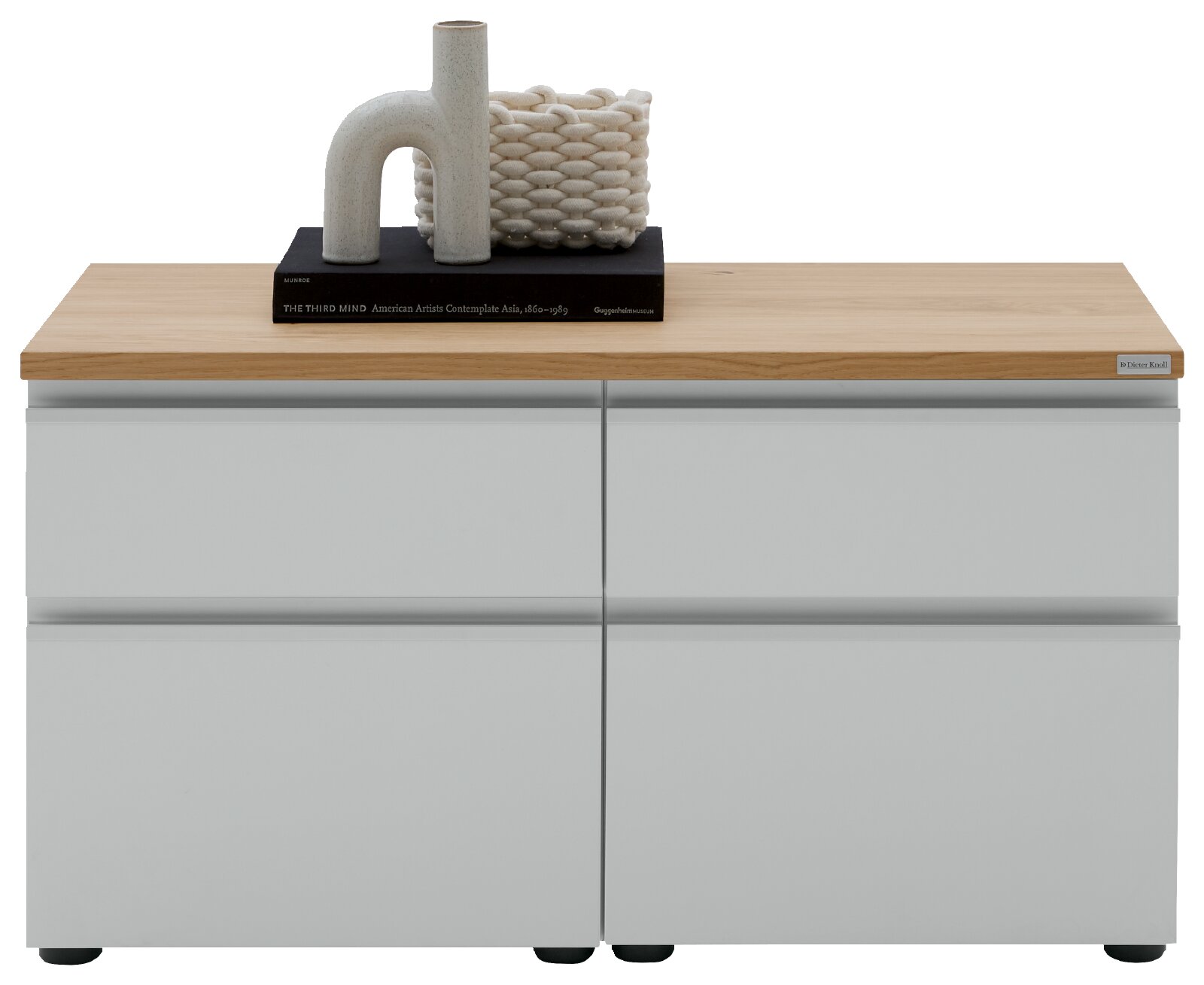 Modernes Sideboard mit hellen, matten Fronten und Holzplatte, vorne frontal in Augenhöhe fotografiert; oben dekoriert mit Vase, Korb und Buch.