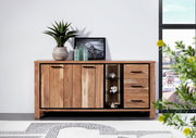 Holz-Sideboard mit drei Türen und drei Schubladen, dekoriert mit Pflanzen und Glasflaschen, aus frontaler Perspektive fotografiert.