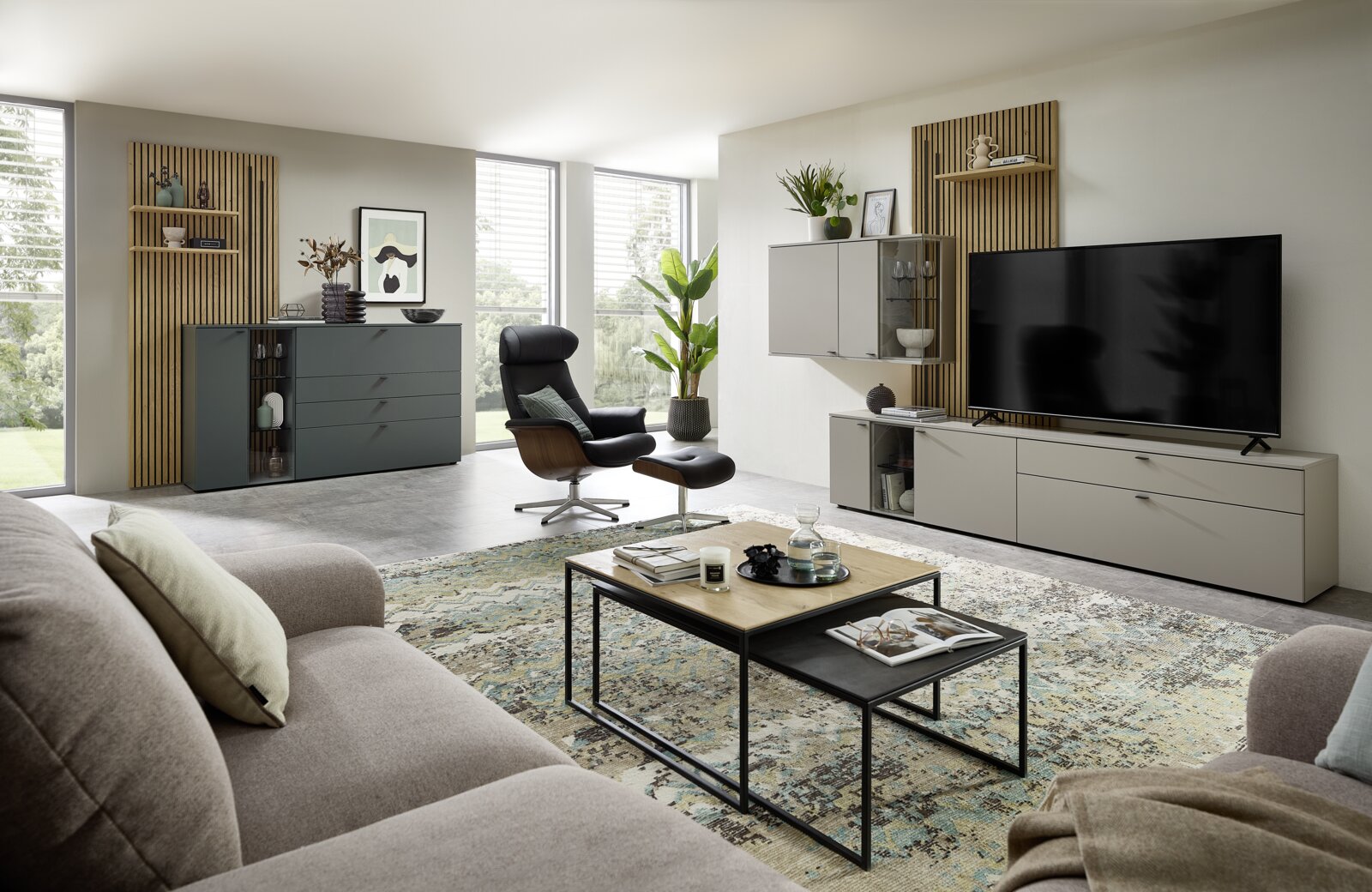 Moderne Wohnzimmeransicht mit Sideboardkombination, bestehend aus einem grauen TV-Schrank und einem dunkelgrauen Sideboard, umgeben von stilvollen Möbeln und Dekorationen.