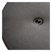 Nahaufnahme der Oberfläche einer Tisch- oder Schreibtischleuchte mit einem zentralen Knopf, von oben betrachtet.