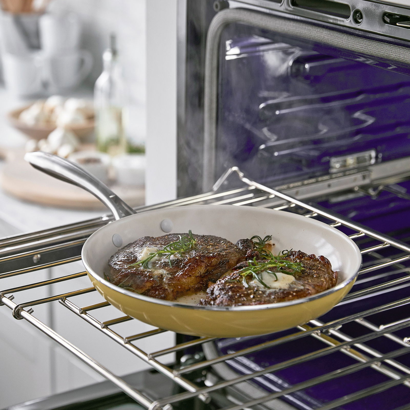 Pfanne mit zwei gebratenen Steaks im Ofen, seitliche Perspektive