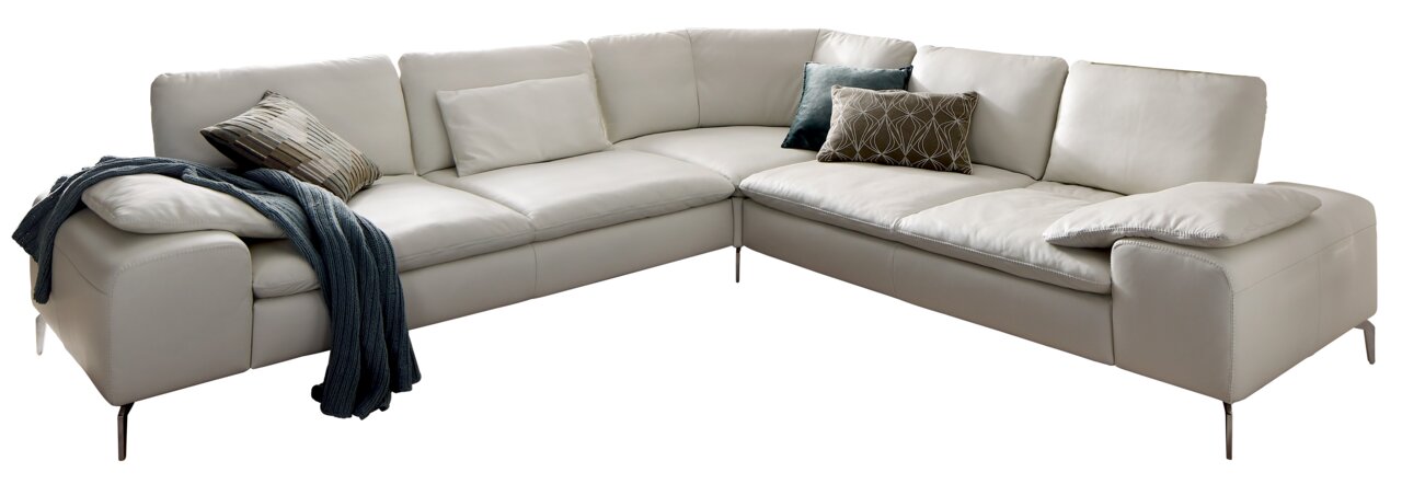 Ecksofa in U-Form aus weißem Leder mit mehreren Kissen und einer Decke, Perspektive von vorne links