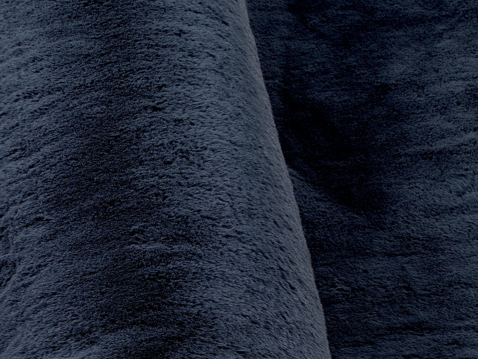 Nahaufnahme eines dunkelgrauen Fellteppichs mit weicher, flauschiger Textur.