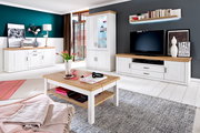 Helles Wohnzimmer-Set im Landhausstil mit weißer Anrichte, Vitrine, TV-Lowboard und Couchtisch in Weiß mit Holzoptik-Platten, frontal in leichter Weitwinkelperspektive fotografiert.