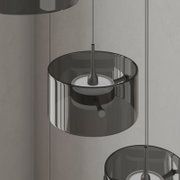 Moderne LED-Hängeleuchte mit rauchgrauem Glas und schwarzem Metall, seitliche Perspektive