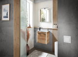 Modernes Gästebad mit hängendem Holzwaschtisch, Spiegel und minimalistischer Dekoration, seitliche Perspektive.