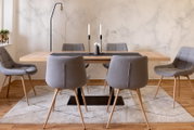 Moderne eettafel met houten blad en zes grijze stoelen, gezien vanaf de voorkant, op een licht tapijt in een stijlvol ingerichte kamer.