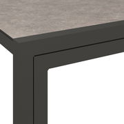Detailansicht einer modernen Lounge-Bank mit grauer Tischplatte und schwarzem Metallrahmen.