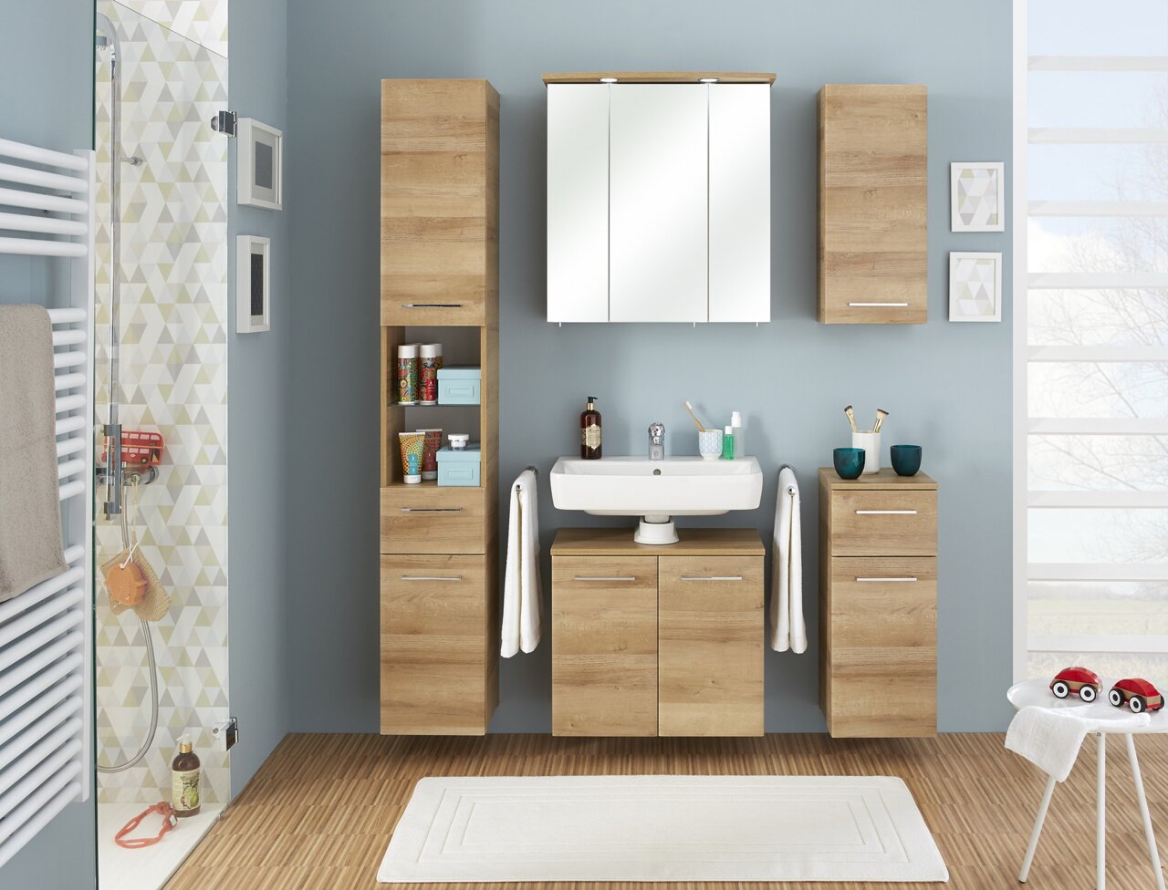 Moderner Badezimmer-Hochschrank in Holzoptik, frontal fotografiert, Teil eines stilvollen Badmöbel-Sets.