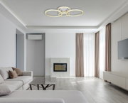 Moderne Deckenleuchte in Nickel matt mit drei leuchtenden Ringen, von unten betrachtet in einem stilvollen Wohnzimmer.