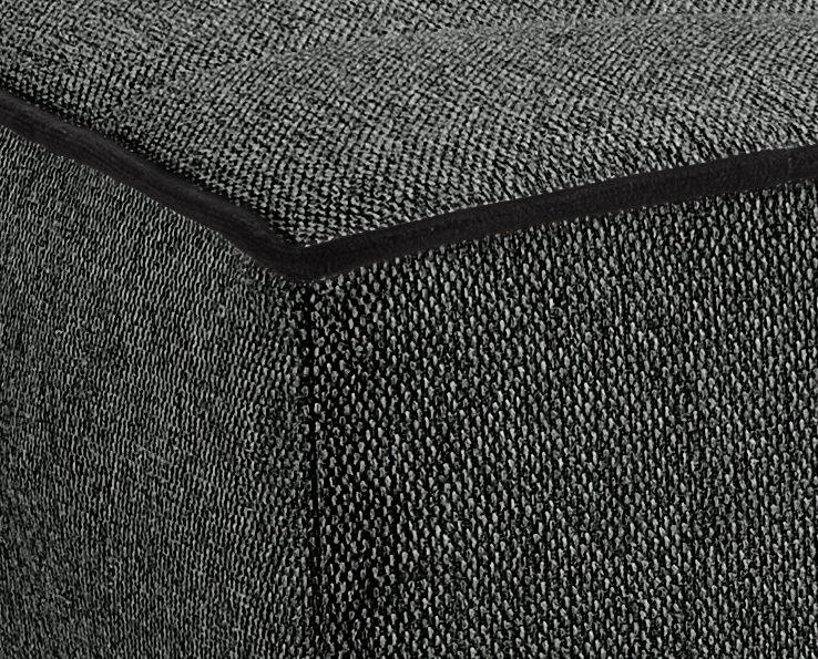 Nahaufnahme einer Ecke eines grauen Schlafsofas mit strukturierter Stoffoberfläche, perspektivisch von oben betrachtet.