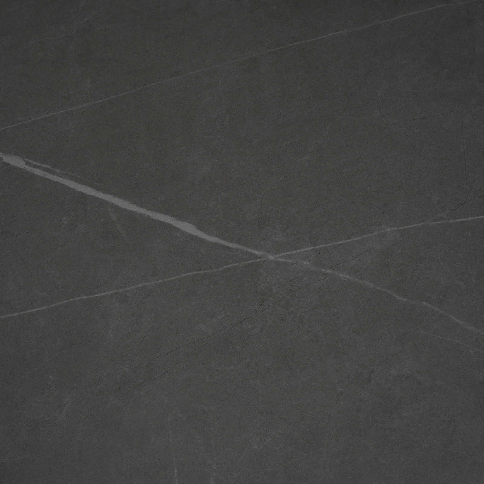 Draufsicht auf eine dunkle, marmorierte Tischplatte mit feinen, hellen Adern.