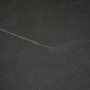 Draufsicht auf eine dunkle, marmorierte Tischplatte mit feinen, hellen Adern.