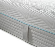 Nahaufnahme einer Gel-Kaltschaummatratze mit gestepptem Muster und blauer Zierleiste, seitliche Perspektive.