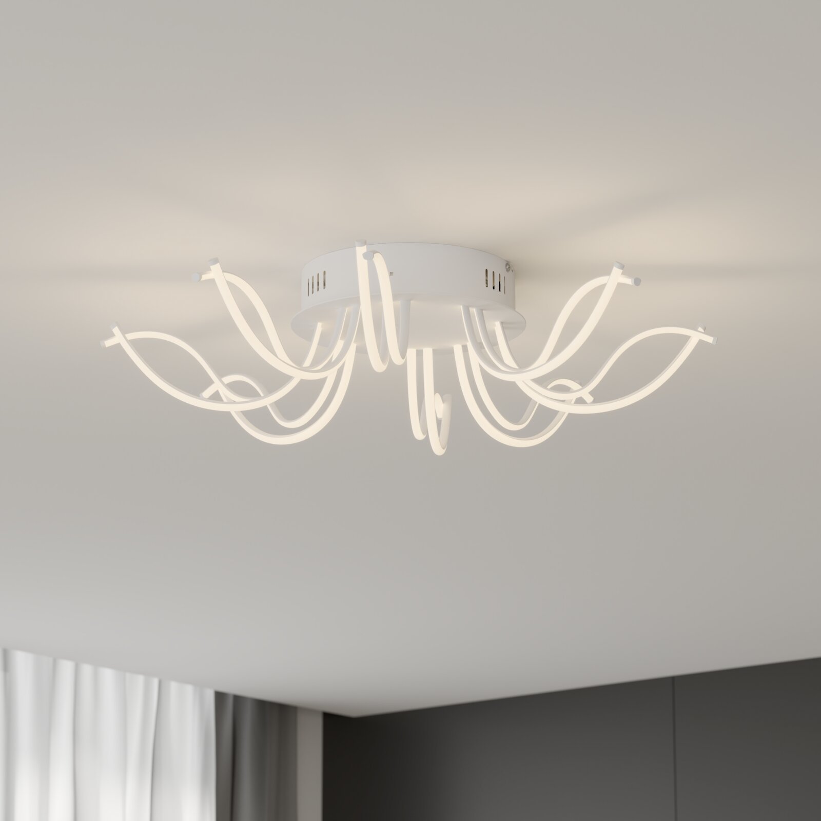 Moderne witte led-plafondlamp met gebogen, lusvormige lichtarmen, van onderaf lichtjes zijdelings tegen het plafond gefotografeerd