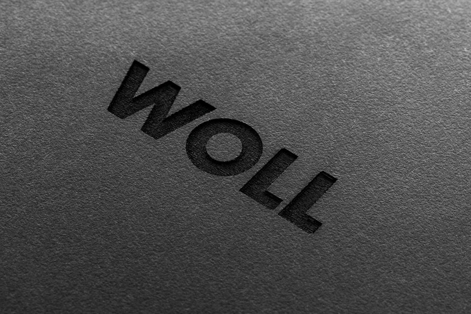 Nahaufnahme eines Schneidebretts mit der Aufschrift 'WOLL' in schwarzer Prägung.