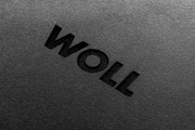 Nahaufnahme eines Schneidebretts mit der Aufschrift 'WOLL' in schwarzer Prägung.
