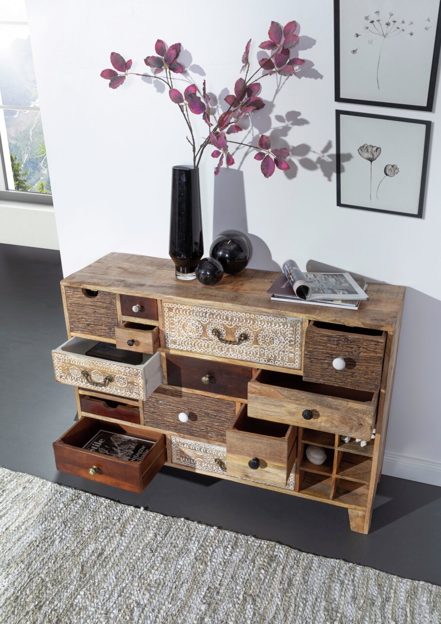Veelzijdig dressoir met diverse lades in een rustieke stijl, versierd met een vaas en kunstvoorwerpen, gezien vanuit vogelperspectief.