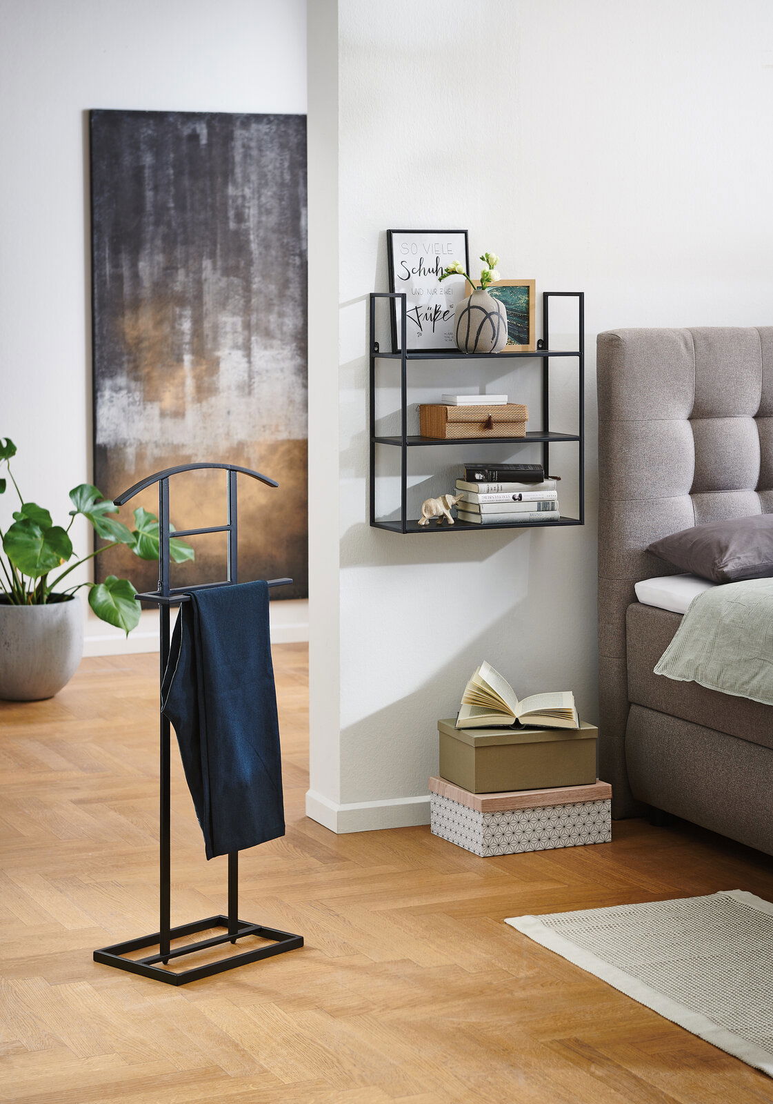 Moderner Herrendiener aus Metall in einem stilvollen Schlafzimmer, seitliche Perspektive.