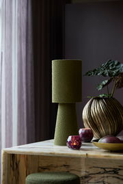 Grüne Vase in modernem Design auf einem Marmortisch, seitliche Perspektive