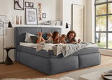 Gemütliches Boxspringbett in einem modernen Schlafzimmer, seitliche Perspektive, mit einer Familie, die darauf entspannt.