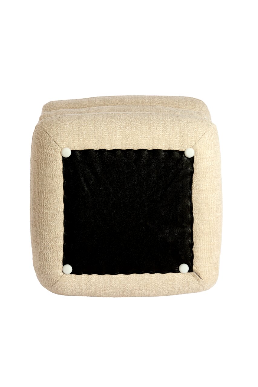 Onderaanzicht van een beige poef met een zwarte stoffen bodem en witte knopen op de hoeken.