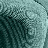 Nahaufnahme eines grünen Hockers mit gerippter Textur, Perspektive von der Ecke.