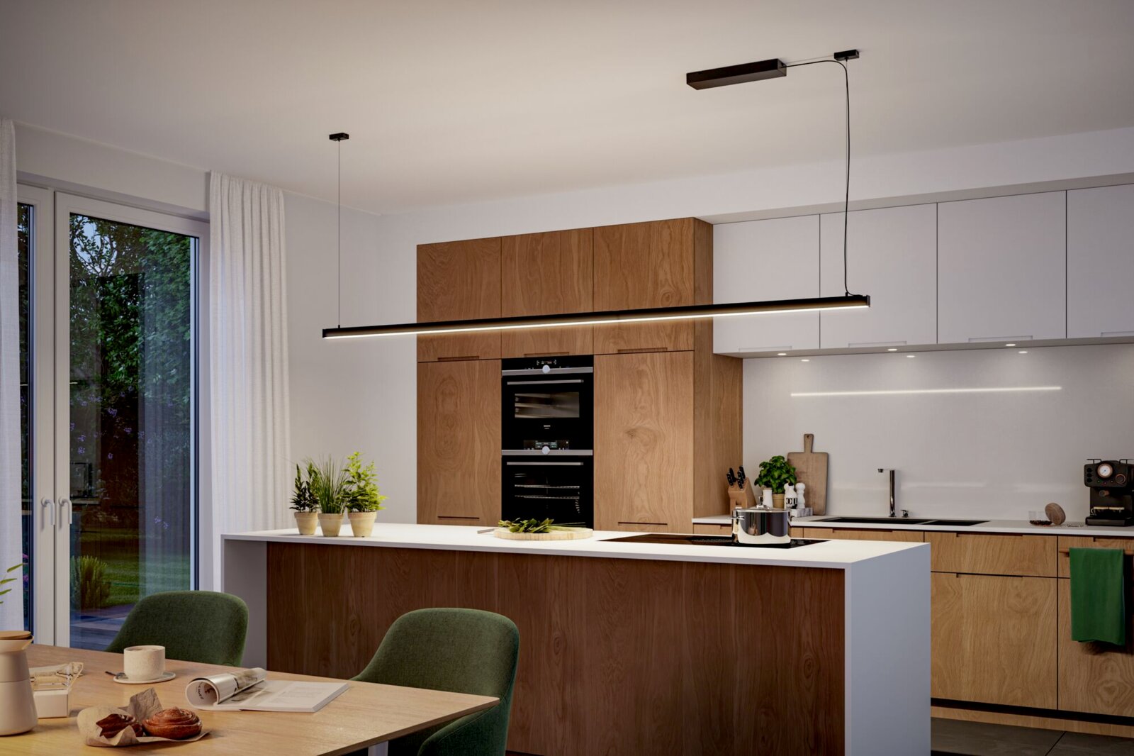 Moderne schwarze lineare LED-Pendelleuchte über einer Kücheninsel in einer hellen Holz- und Weißküche, Ansicht schräg von vorn auf Augenhöhe