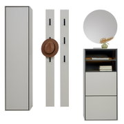 Moderne Garderobenmöbel in Hellgrau mit schwarzem Rahmen: hoher Schrank in Frontansicht, zwei Wandpaneele mit Haken (eines mit Hut) sowie Kommode mit offenem Regal und rundem Spiegel, dargestellt in frontaler Perspektive auf weißem Hintergrund.