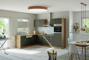 Moderne L-vormige hoekkeuken met donkere fronten en een houtlook, voorzien van een fornuis, oven en spoelbak, in een lichte ruimte met uitzicht op de eethoek.