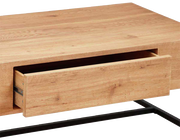 Nahaufnahme eines Couchtisches aus Holz mit einer geöffneten Schublade und einem schwarzen Metallgestell, seitliche Perspektive.