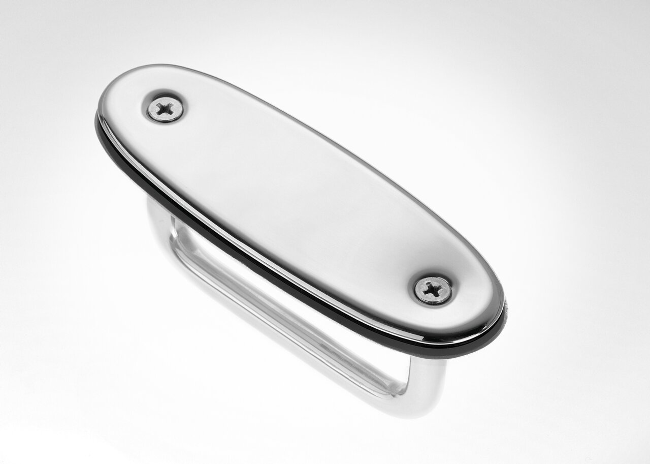 Nahaufnahme eines glänzenden, ovalen Metallgriffs mit zwei Schrauben, perspektivisch von oben fotografiert.