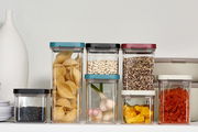 Vorratsdosen Omnia in verschiedenen Größen und Farben, gefüllt mit Lebensmitteln, aus frontaler Perspektive.