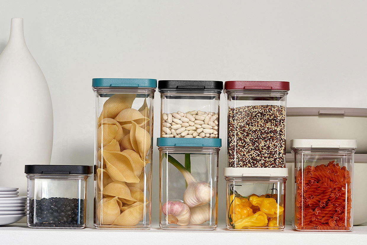 Vorratsdosen Omnia in verschiedenen Größen und Farben, gefüllt mit Lebensmitteln, aus frontaler Perspektive.