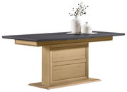 Moderne functionele eettafel met een donker tafelblad en een licht houten onderstel, gezien vanaf de zijkant, versierd met twee witte vazen.