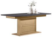 Moderner Funktions-Esstisch mit dunkler Tischplatte und hellem Holzgestell, seitliche Perspektive, dekoriert mit zwei weißen Vasen.