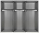 Innenansicht eines sechstürigen Drehtürenschranks mit drei großen Fächern, jeweils mit einer Kleiderstange und einem Regalboden, aus der frontalen Perspektive.