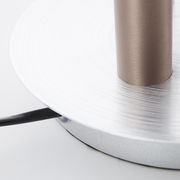 Nahaufnahme der Basis einer Cembalo LED Lampe mit silberner, kreisförmiger Struktur und einem Kabel, das von der Seite herausragt.