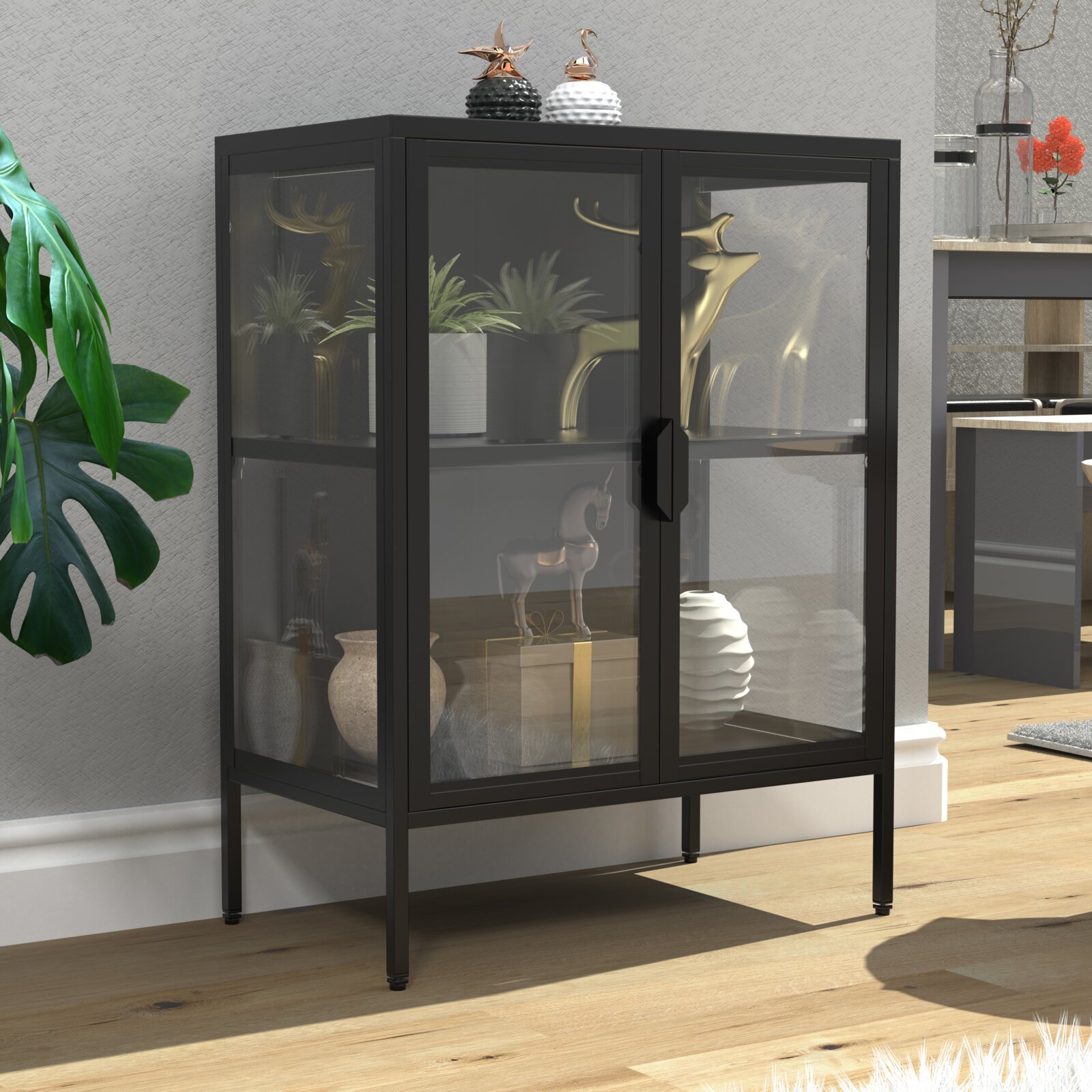 Schwarzer Vitrinenschrank aus Metall mit Rauchglas-Front und zwei Türen auf hohen Beinen, im Wohnzimmer mit Deko bestückt; Perspektive: leicht von vorne links in Augenhöhe
