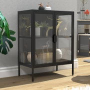 Schwarzer Vitrinenschrank aus Metall mit Rauchglas-Front und zwei Türen auf hohen Beinen, im Wohnzimmer mit Deko bestückt; Perspektive: leicht von vorne links in Augenhöhe