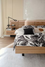 Satin-Bettwäsche 155x220 cm mit floralem Muster in einem modernen Schlafzimmer, seitliche Perspektive.