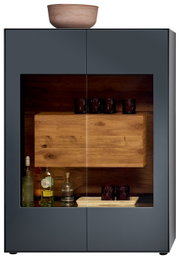 Frontansicht eines modernen Highboards mit Glasfront, dunklem Holzinterieur und dekorativen Gläsern und Flaschen.